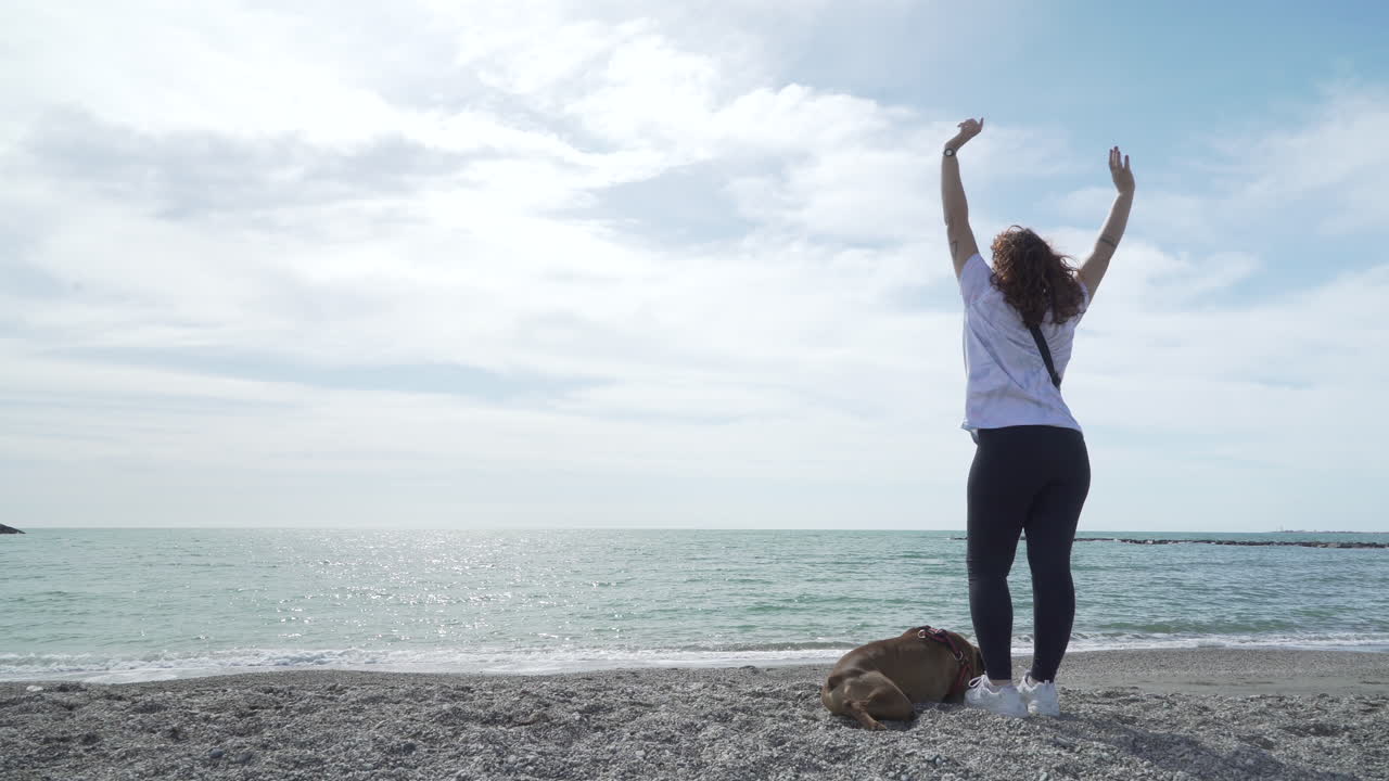 Girl with her boxer dog at the beach