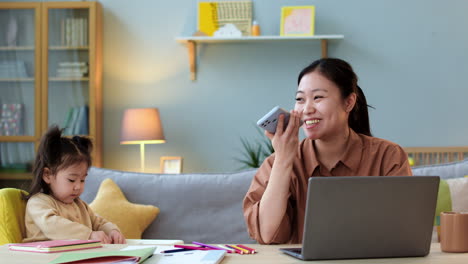 Mujer-Asiática-Usando-Un-Teléfono-Inteligente-Sentado-En-Una-Mesa