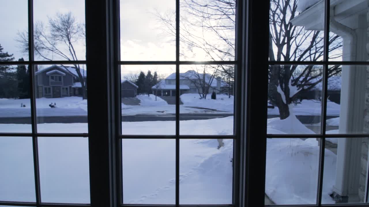 겨울 동안 미네소타 주 에덴 프레리에서 눈 덮인 거리의 분할 창을 통해 보기