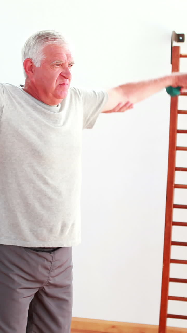 수석 남자 가 훈련사 의 도움 으로 손 무게 를 들어 올리고 있다