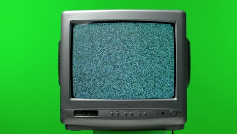 old tv set in the studio on a green screen of chroma key. white noise effect on the screen. analog static noise texture. monochrome, black and white offset flicker. screen damage. close up