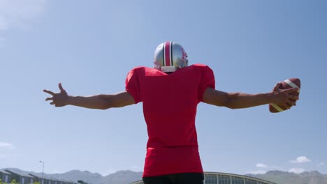 american football player standing with arms raised