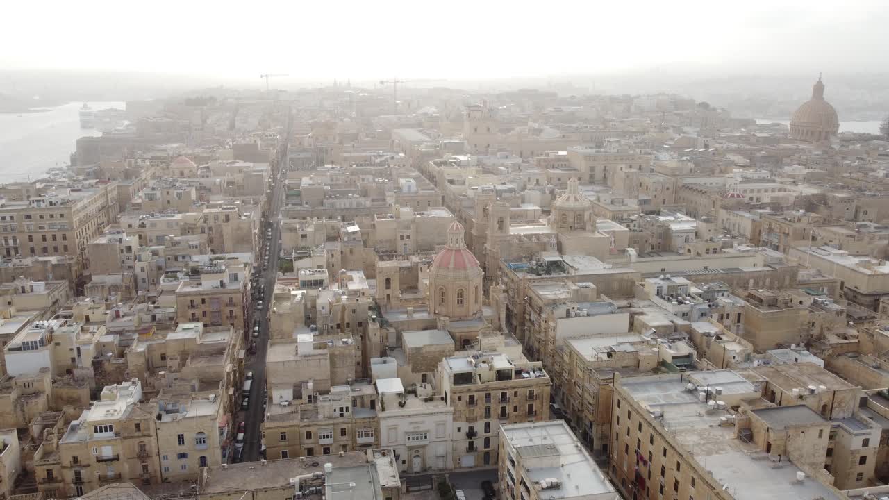 Volo lento ad alta quota sopra il centro storico della città di La Valletta, Malta, nella foschia