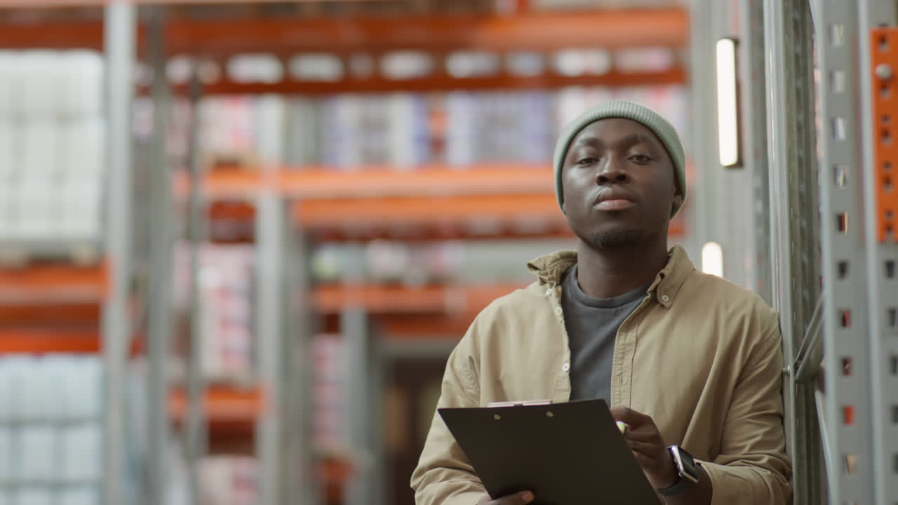 African American Man Working in a Warehouse with a Clipboard