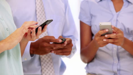 Business-team-all-using-their-smartphones