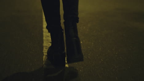 Girl-walking-on-street-alone-in-boots-on-road-downtown-city-centre.