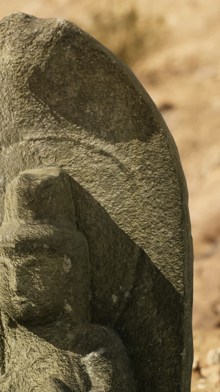 Historic stone sculpture located in an arid landscape during daylight hours