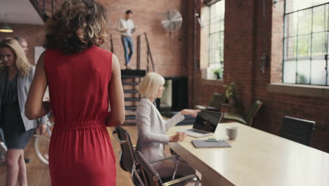 Mixed-race-business-woman-walking-through-busy-office