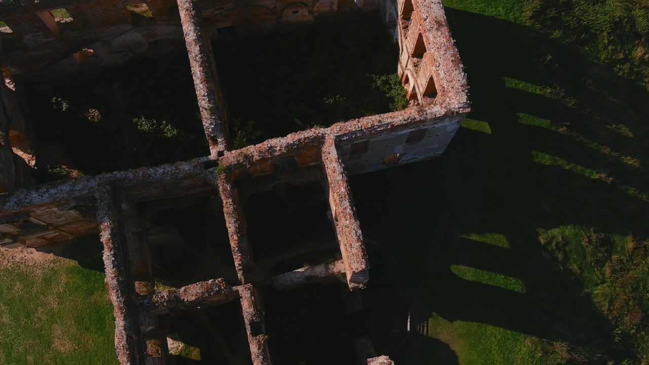 Vista aérea cenital de la fachada de ruinas de un palacio con ventanas vacías y patrón geométrico en Bielorrusia.