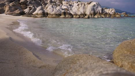 close shot of the clear water splashing on the kavourotripes beach in sithonia, chalkidiki, greece