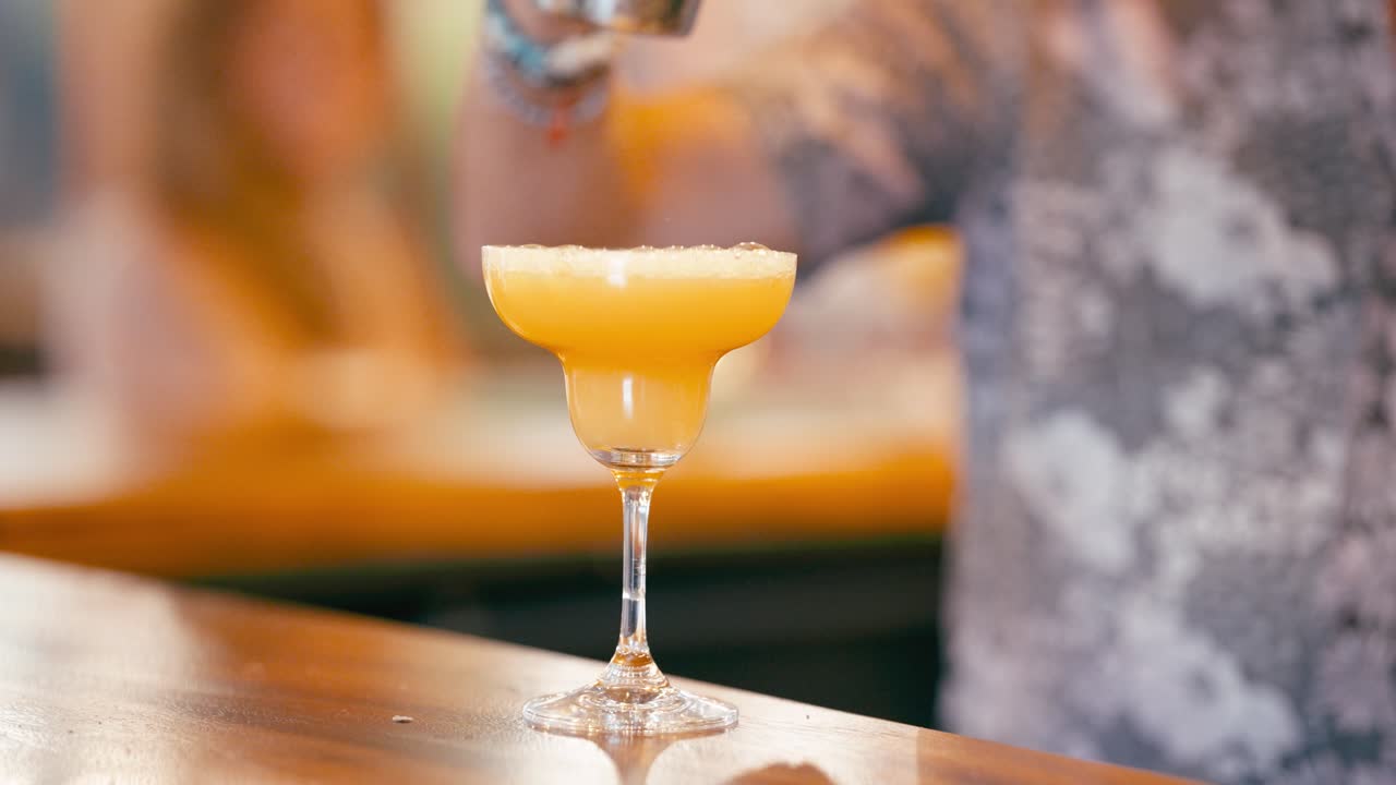 Bartender Servindo um Refrescante Coquetel Amarelo em uma Taça de Margarita