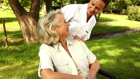 Krankenschwester-Spricht-Mit-Frau-Im-Rollstuhl-Draußen