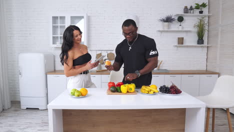 multiracial couple discussing products at the light kitchen. happy people creating healthy menu and having fun.