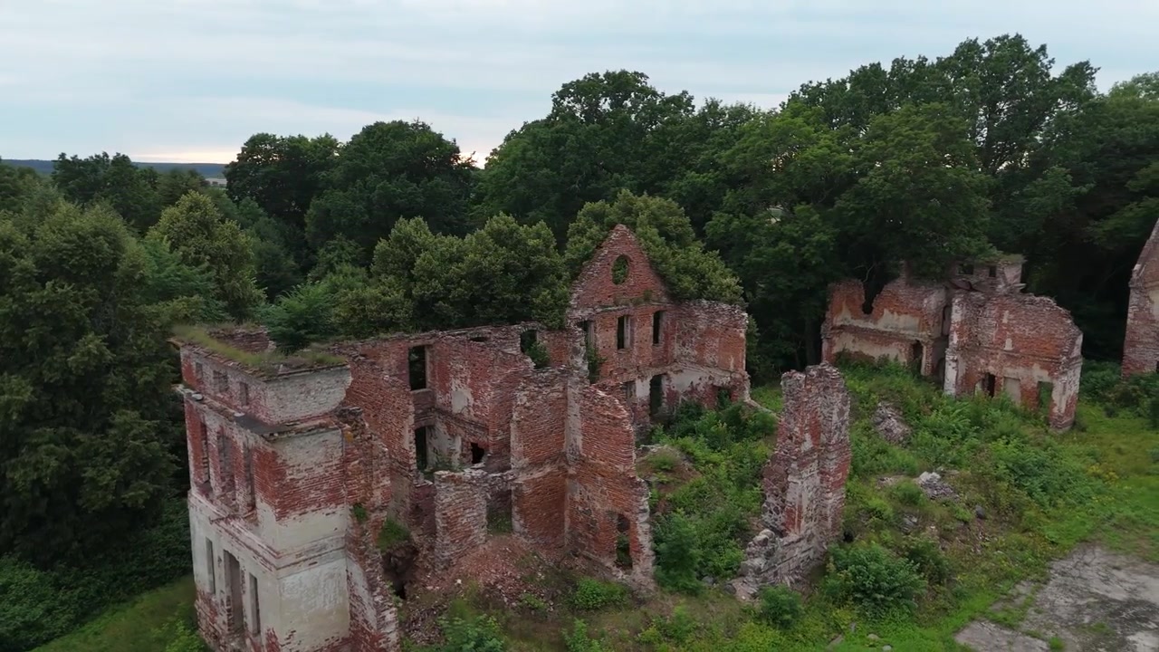 Elokuvallista dronekuvaa Latvian historiallisista Zleku-kartanon raunioista. Ilmakuvat paljastavat vaikuttavat kiviseinät, ympäröivän vihreän maiseman ja tämän historiallisen arkkitehtonisen maamerkin kauneuden.