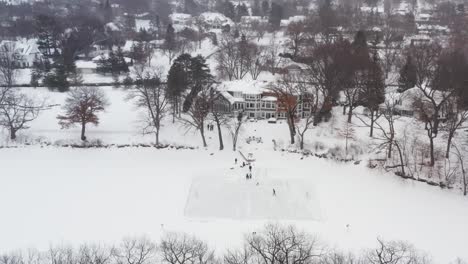 aerial, family and friends skating on a homemade backyard ice hockey rink