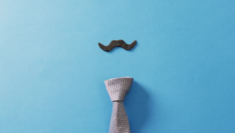 video de bigote falso y corbata en fondo azul con espacio para copiar.