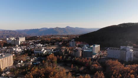 antena de rotación lenta sobre una hermosa ciudad en las montañas durante los colores del otoño