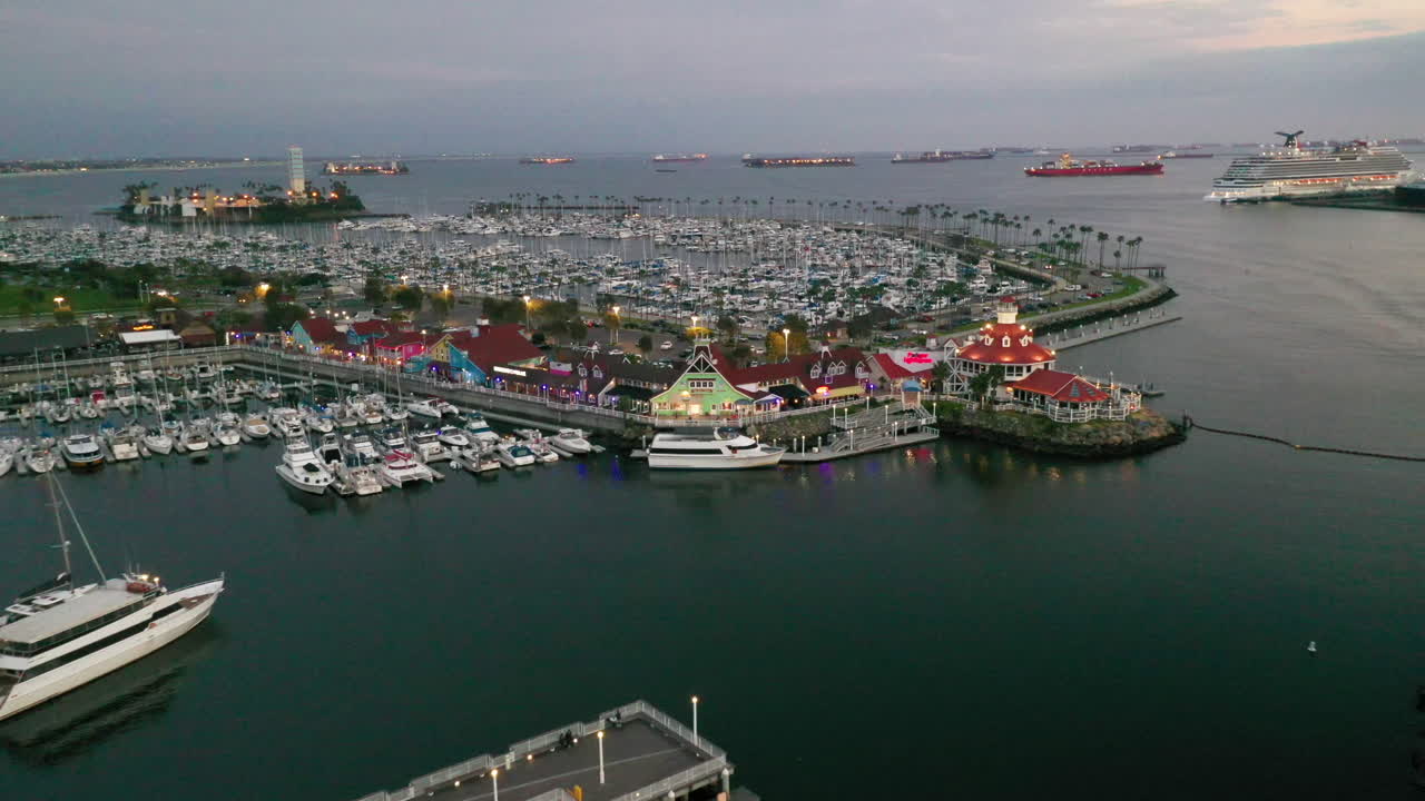 Long Beach Harbour California, USA. Beautiful aerial shot of houses, trees, blue water and the lighthouse. Establishing shot of the area at dusk with colourful buildings