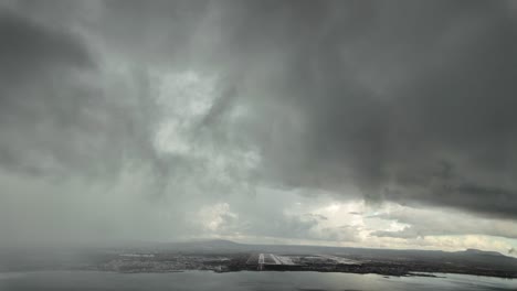 immersive pilot’s perspective fpv in a real time approach to palma de mallorca airport runway at the eyes of the pilots while flying through a stormy sky with rain. 4k 60fps