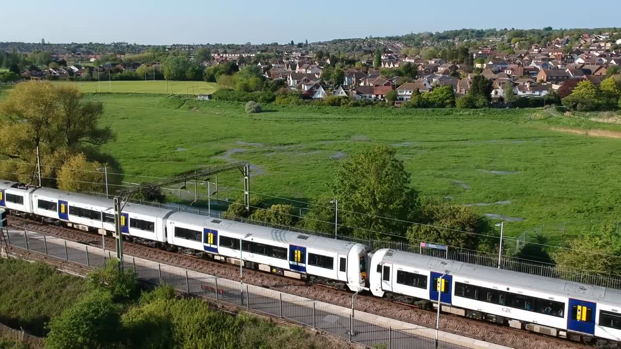 vista aérea de un tren que llega a una aldea en el campo británico