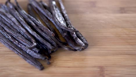 granos de vainilla secos sobre un fondo de madera con espacio para copiar