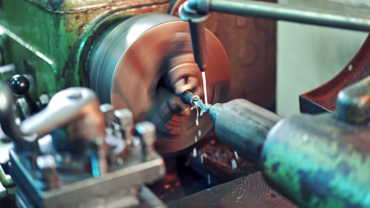 Lathe machine is turning while cutting metal on the workshop background. CNC milling machine on a factory. Metalwork