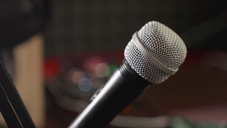 close-up shot of a microphone on a stand with a blurred background, highlighting the microphone as the focal point. with the blurred background adding depth and context