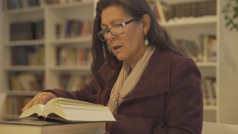 retrato de una anciana leyendo un libro histórico en la biblioteca de la universidad, primer plano