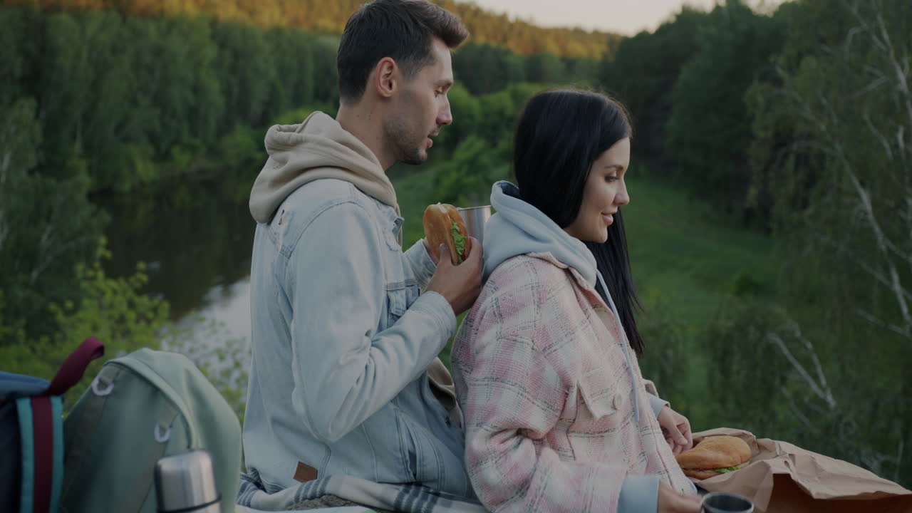 Couple enjoying a picnic in the forest by the river
