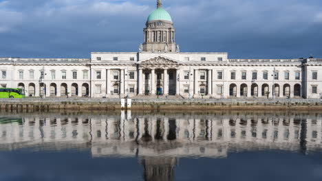 Lapso-De-Tiempo-Del-Edificio-Histórico-De-La-Casa-Personalizada-En-La-Ciudad-De-Dublín-Durante-El-Día-Con-Una-Reflexión-Sobre-El-Río-Liffey-En-Irlanda