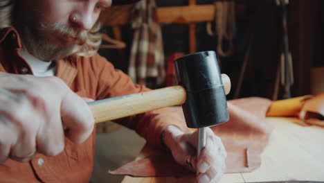 craftsman hole punching leather strap with hammer