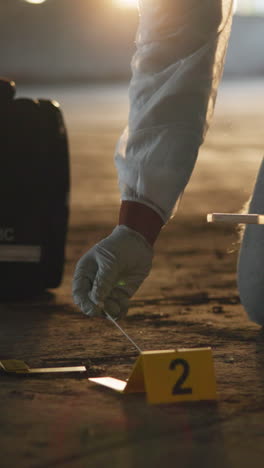 a forensic investigator collects evidence from a crime scene