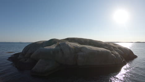 4k shot of a big lonely rock in the blue ocean sea outside gothenburg, sweden