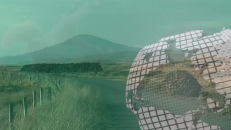 globe animation over rural landscape with mountains and grassy fields