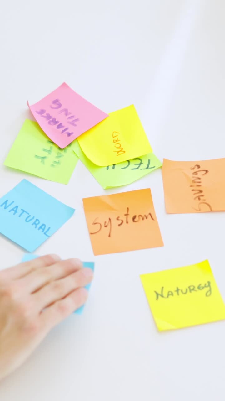 People using adhesive notes to write ideas on a table