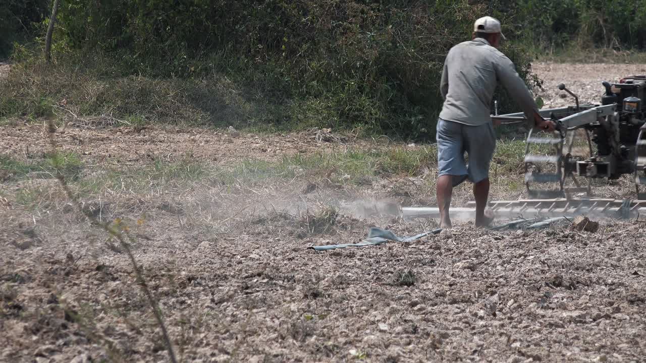 amplia toma estática exterior de un hombre arando el campo en el día