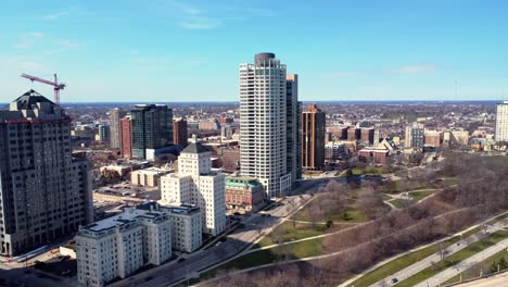 aerial flyby of large apartment buildings along a road and park