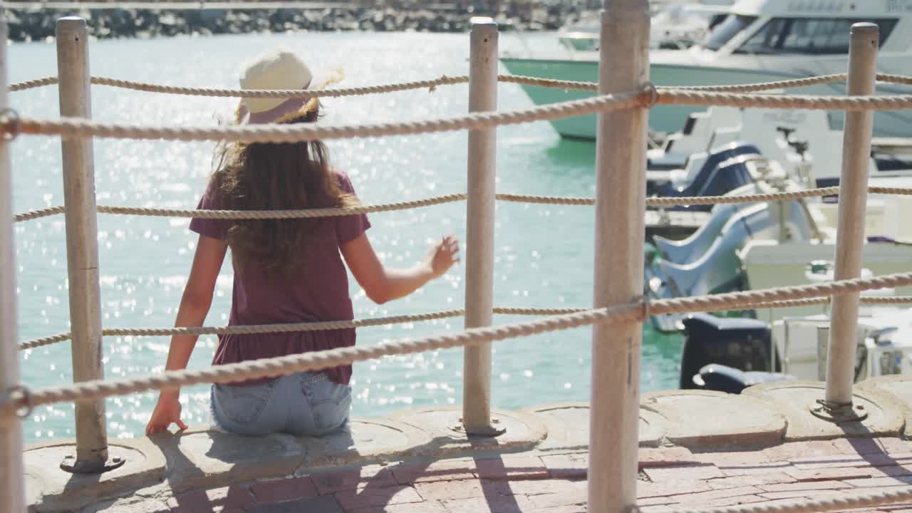 задний вид подростка кавказской девушки на стороне гавани