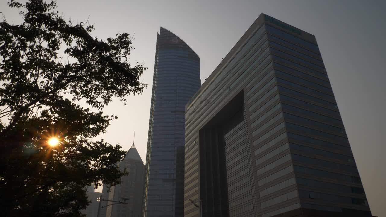 hora de puesta de sol ciudad de qingdao centro de la ciudad modernos edificios de oficinas frente a la cámara lenta panorama 4k china