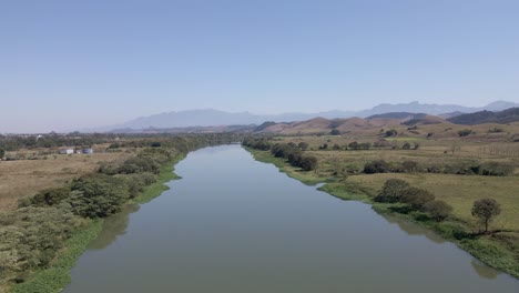 Fluss-Paraíba-Do-Sul-Im-Brasilianischen-Auwald-Und-Abholzung-Mit-Luftaufnahme-über-Das-Grüne-Wasser-In-Den-Hintergrundbergen