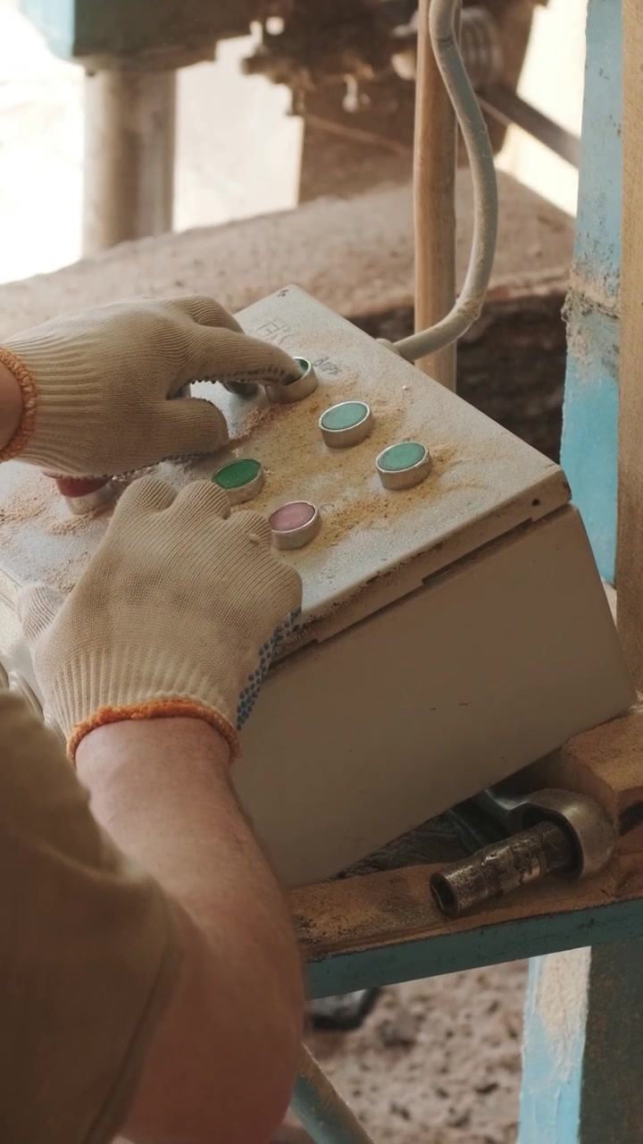 Worker Operating Industrial Control Panel in Woodworking Workshop