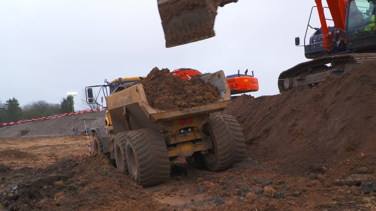 덤퍼에 흙을 싣는 굴착기