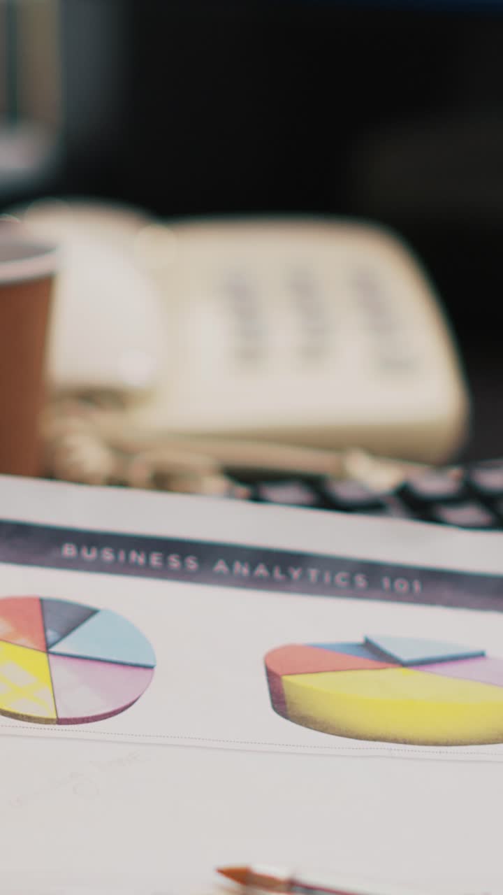 Vertical video Cup of coffee and paperwork on office desk, close up