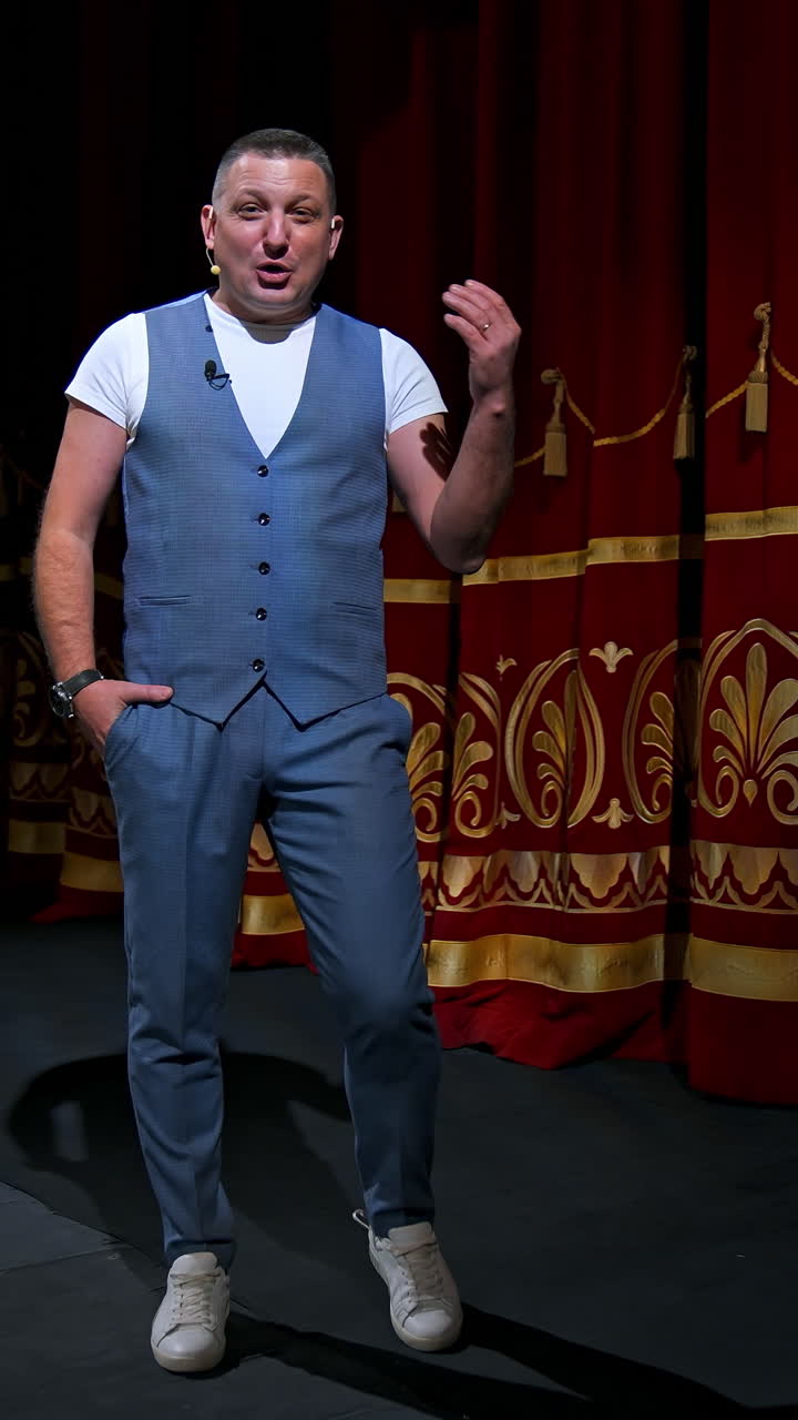 Man in suit speaking jokes in microphone standing on stage. Funny performance. Comedian in good humor speaks to the audience. Vertical video