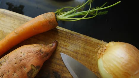 Onion,-carrot-and-sweet-potato-with-knife-at-home-4k