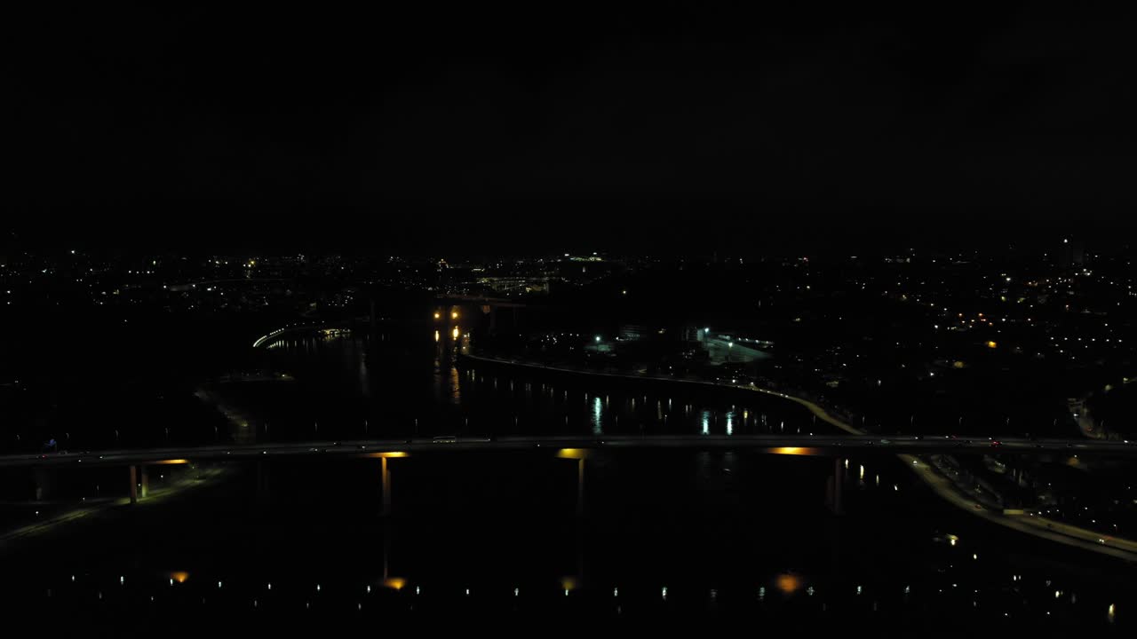Drone view of illuminated Oporto riverside and bridge after dark