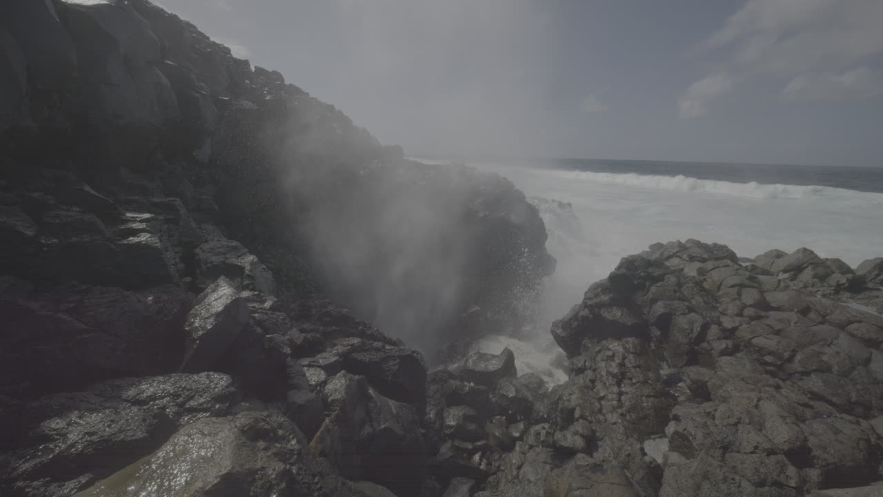 Powerful Waves Crashing Through a Blowhole on Volcanic Coastline