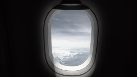 Clip-De-4k-De-Una-Ventana-De-Avión-Tomada-Desde-La-Cabina-Mientras-Viajaba-Y-Volaba-En-Un-Día-Tormentoso-Con-Nubes-Oscuras-Y-Aterradoras-En-El-Cielo