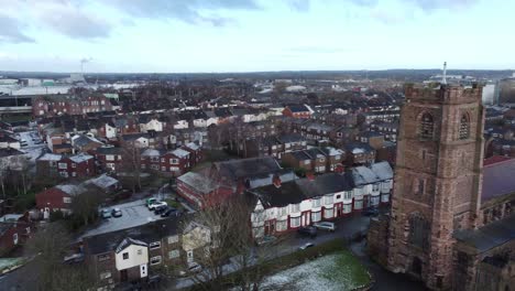 aerial view industrial small town frosty church rooftops neighbourhood north west england pan left