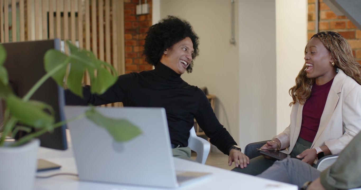 African American women coworkers, left woman opening discussion, pointing at monitor, collaborating